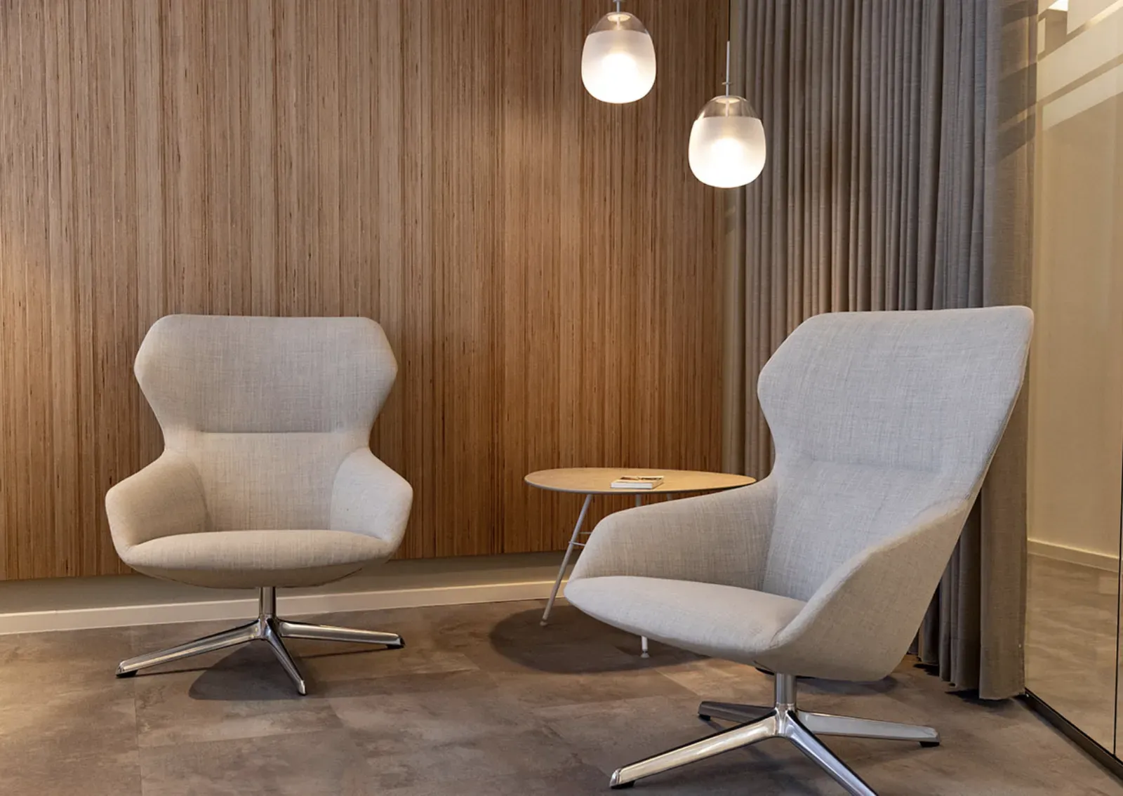 Lounge with two armchairs in front of a wooden wall