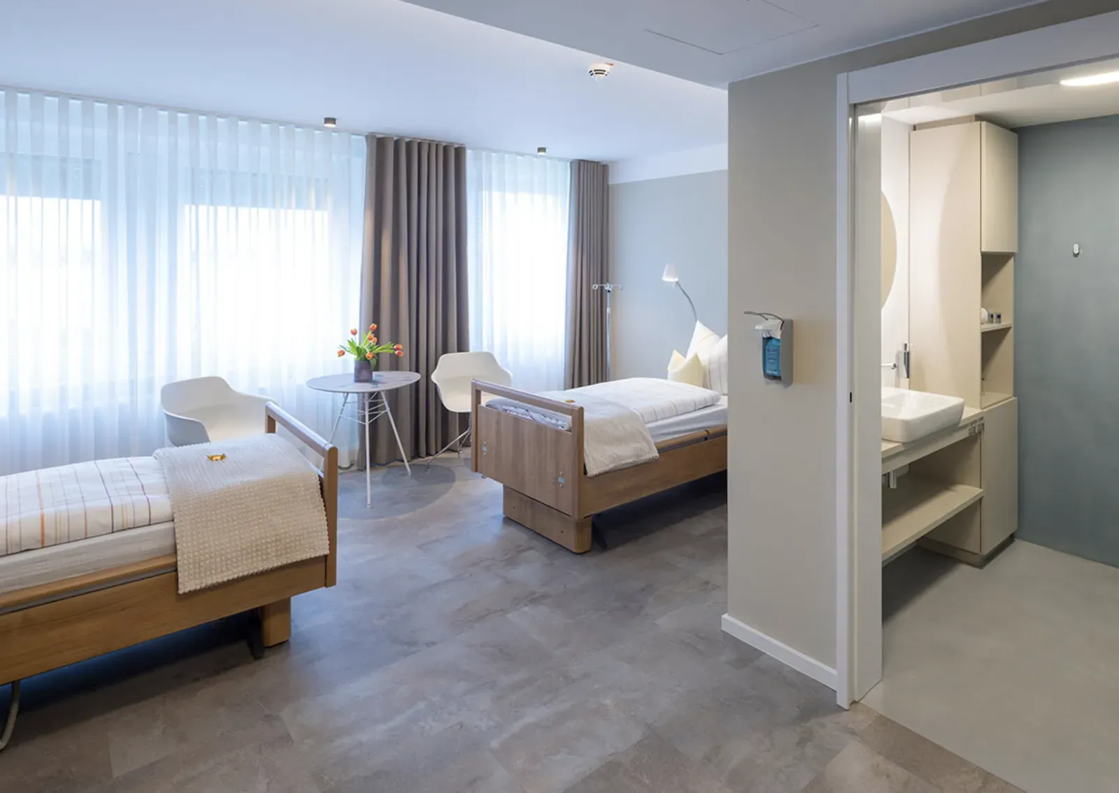 Patient room with two beds and its own bathroom
