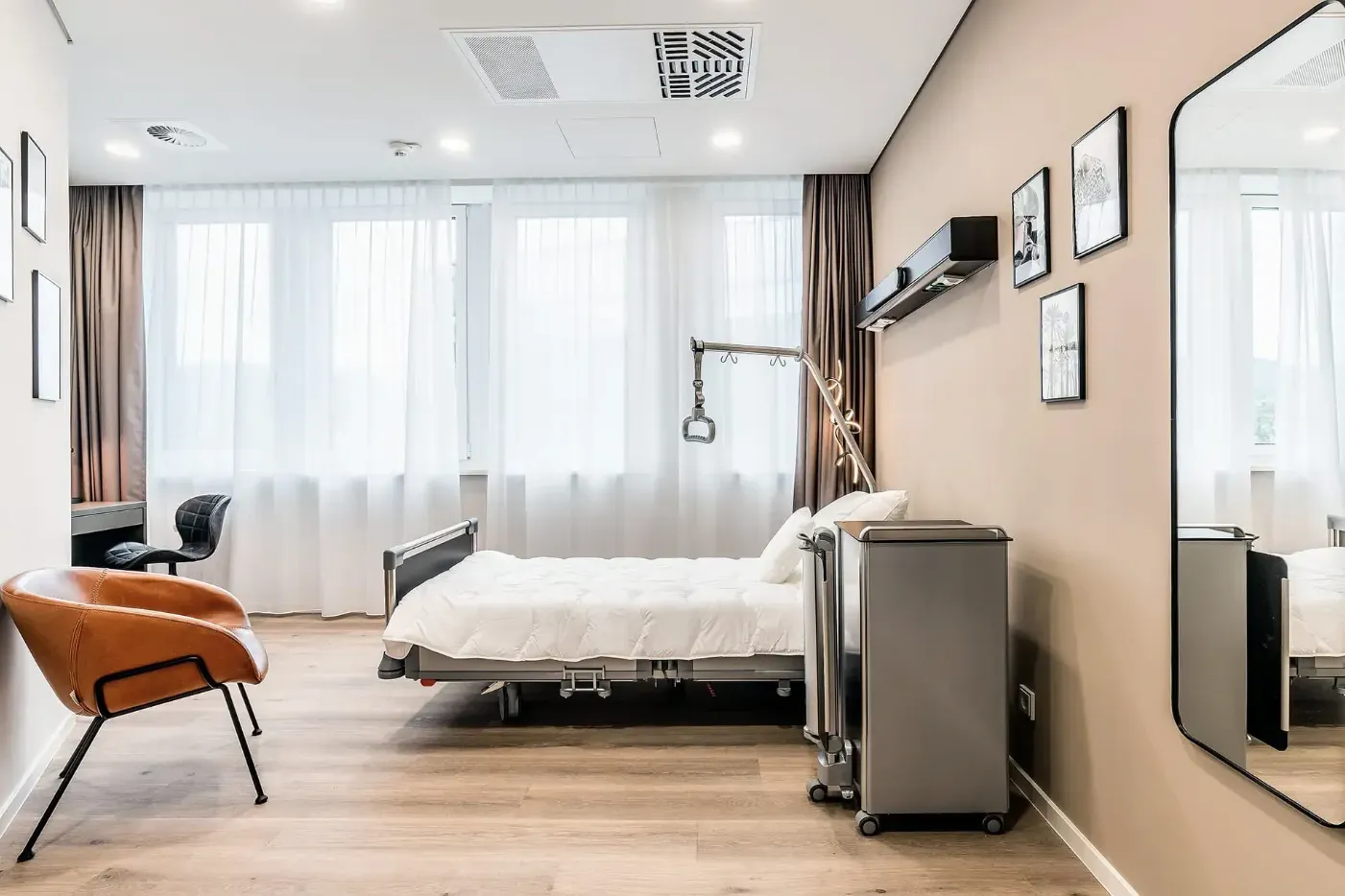 Patient room with nursing bed, armchair and mirror
