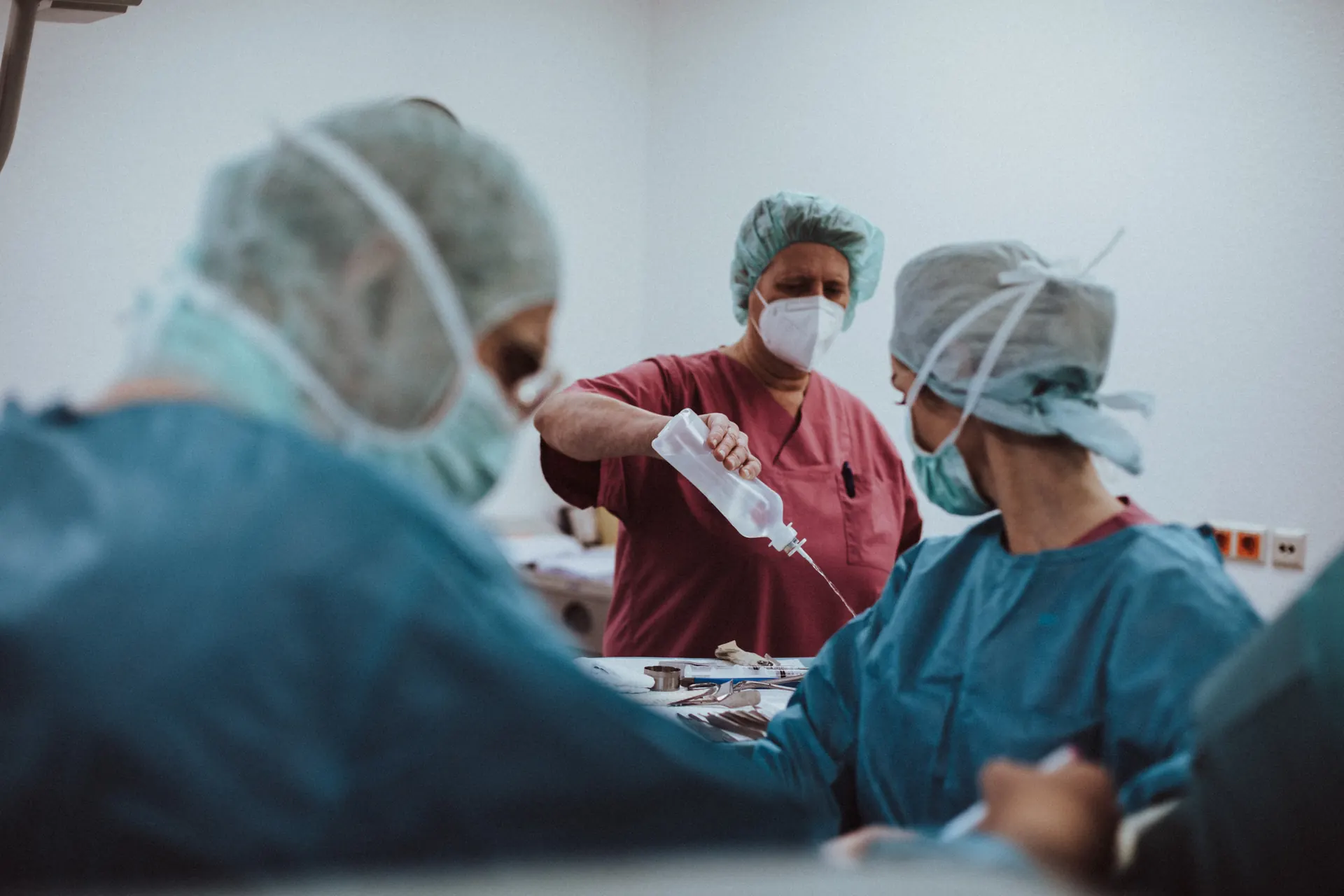 Chirurgin und OP-Pflege arbeiten am OP-Tisch zusammen