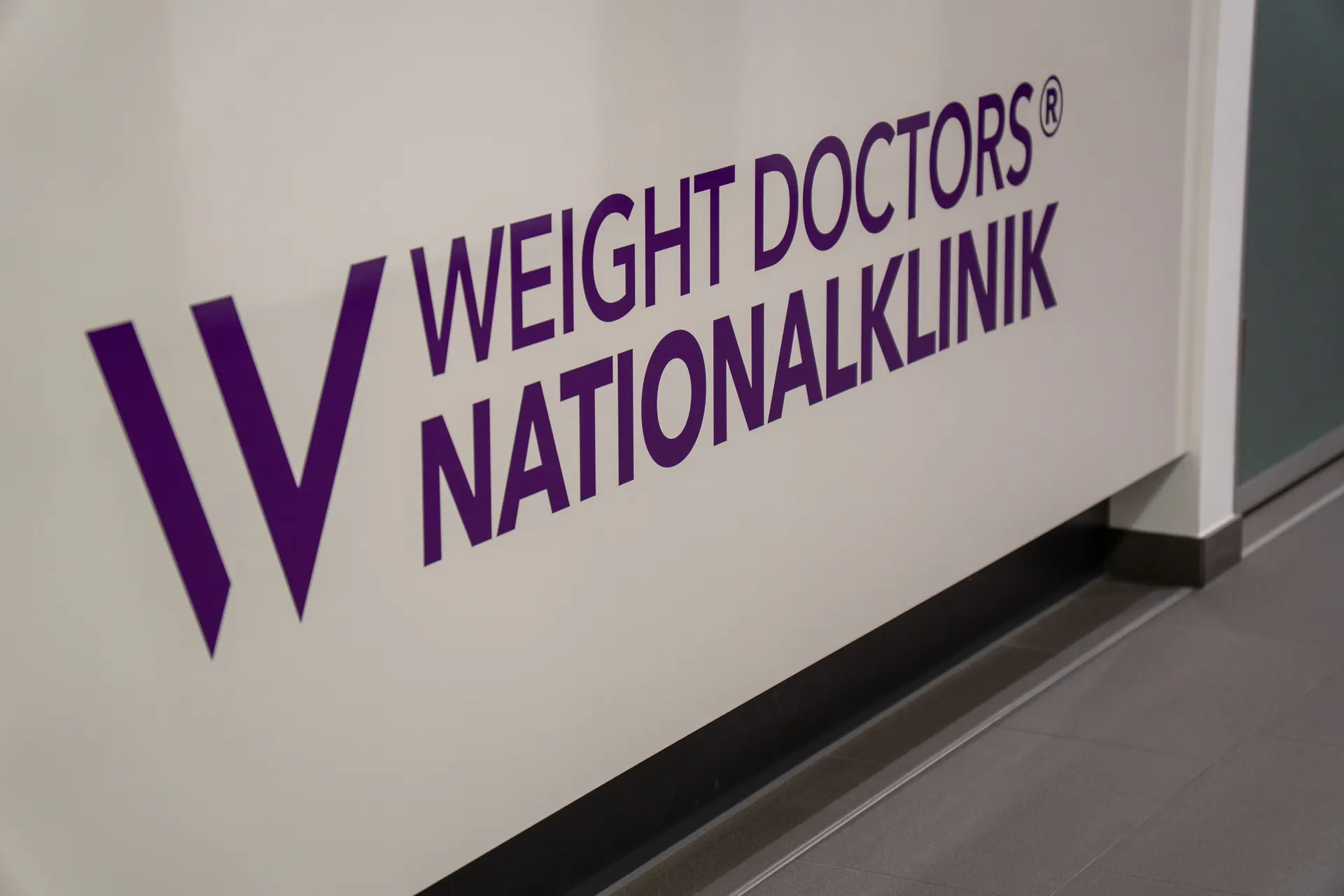Reception of the Weight Doctors® Nationalklinik with the logo on the counter