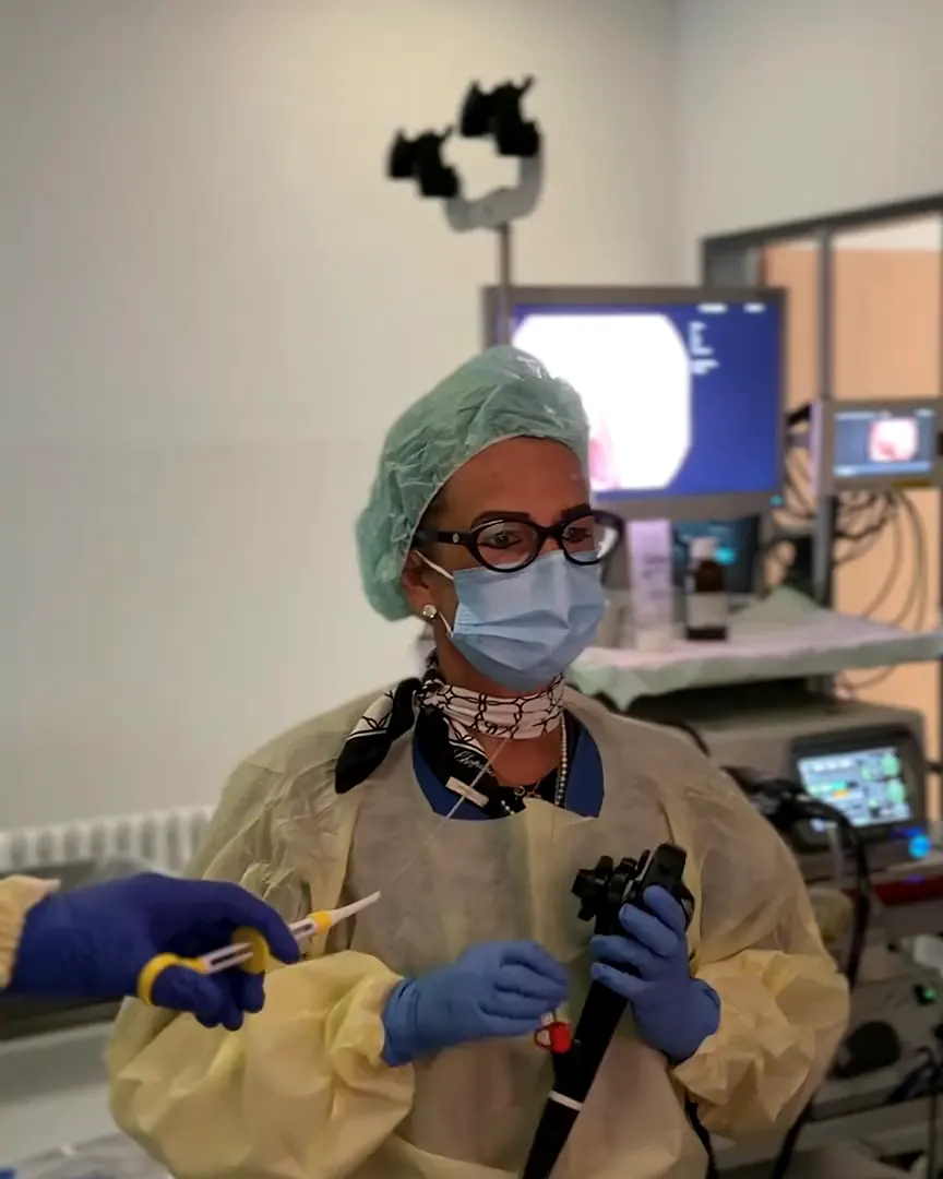 Une médecin avec l’endoscope devant les moniteurs dans la salle d’examen